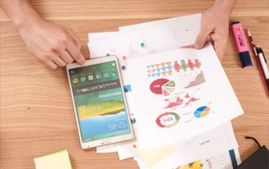 Photographer working on charts and graphs at a desk