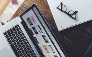 desk with notepad and laptop