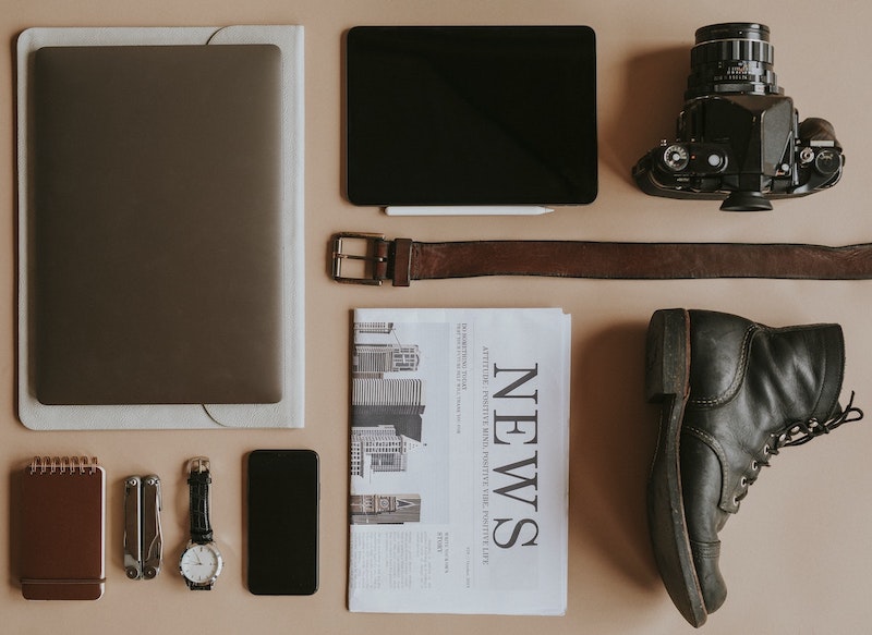 newspaper on desk with camera and computer