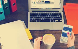 Lady drinking coffee while working at her computer