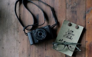 Photo of camera with quote notebook on desk