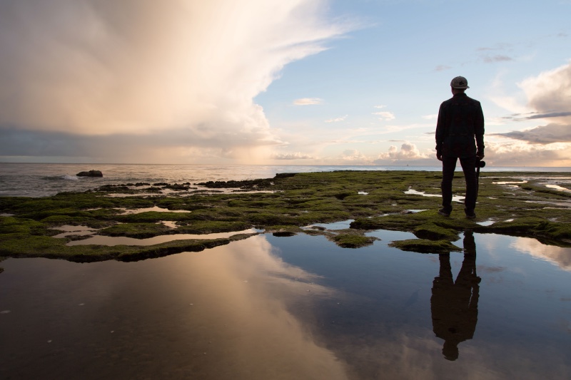 man standing by a lake sunset