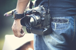 man carrying nikon camera