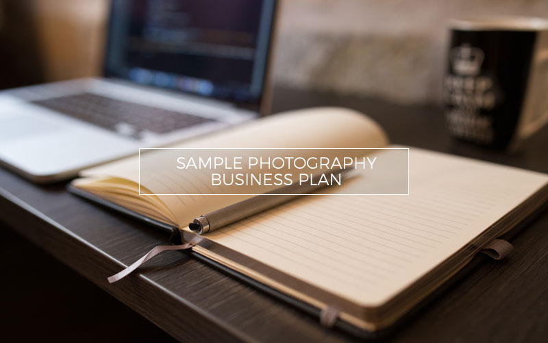 Pen and penciled business plan next to computer