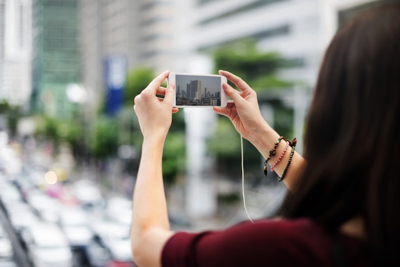 woman taking cityscape with phone camera