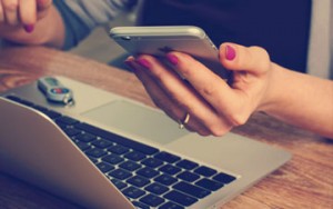Photographer with pink fingernails on a mobile phone