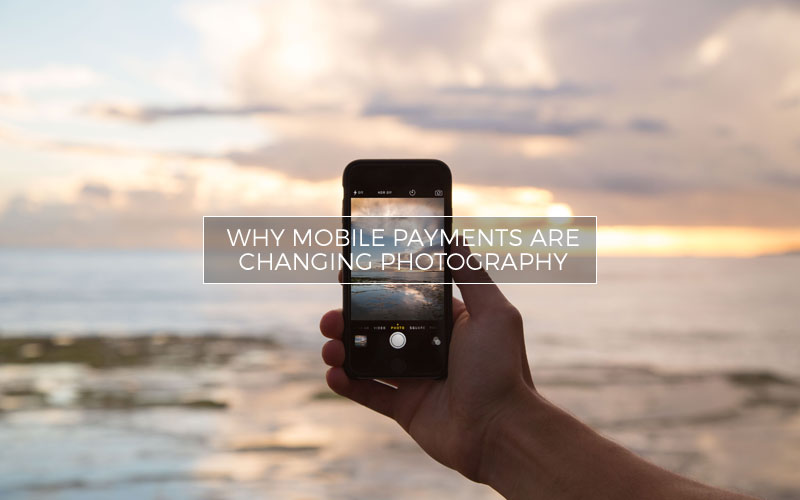 Person holding mobile phone by the ocean